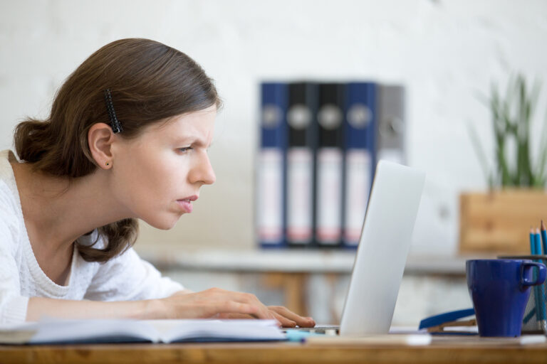 Woman looking concerned at their laptop.