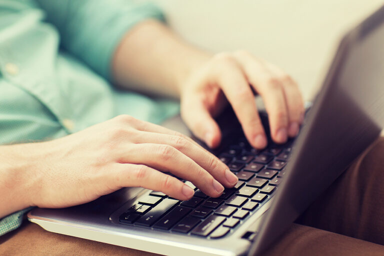 Close up of man working with laptop computer.