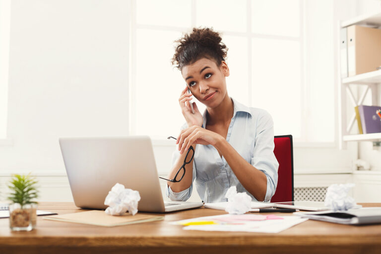 Woman in office being bored while on the phone.