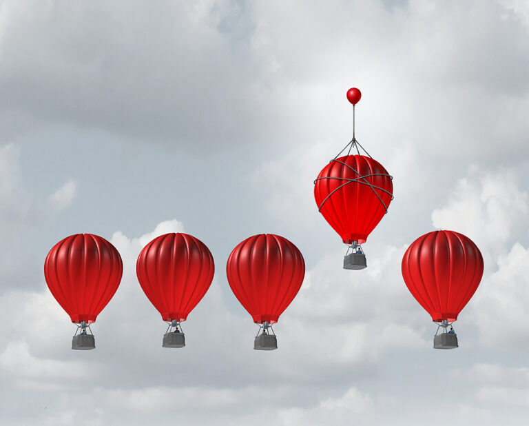 Five red hot air balloons in a cloudy gray sky, with one hot air balloon slight higher than the others with the help of a smaller balloon tied to the top. A picture meant to show the competitive edge of cross-selling vs. upselling.