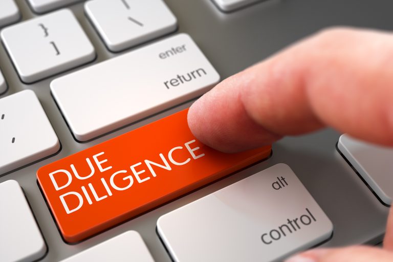 Finger pressing "Due Diligence" button on keyboard.