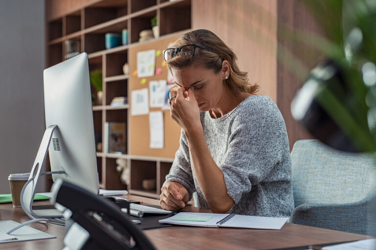 Exhausted businesswoman having a headache at her office.