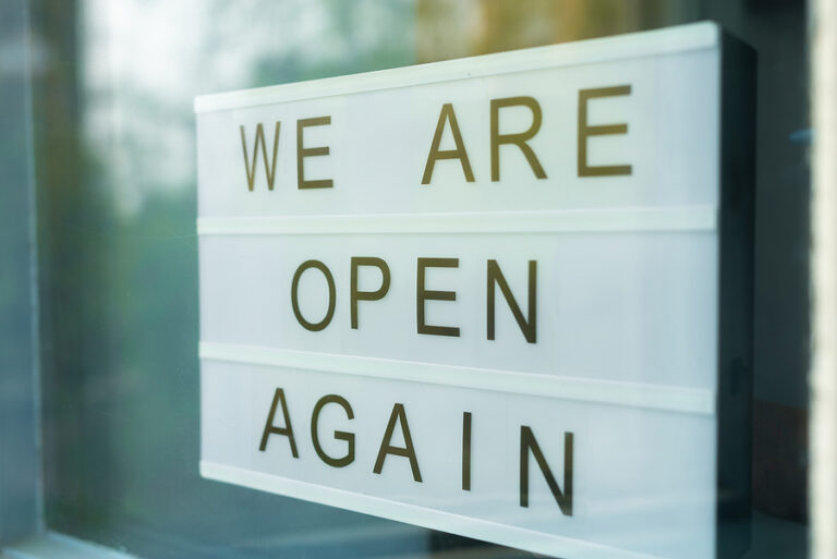 Business sign that says "We are open again."