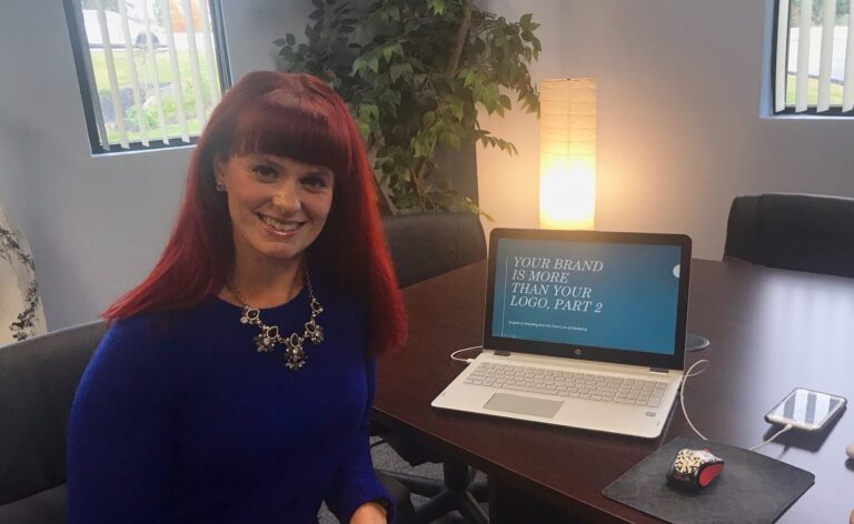 Julia Becker Collins at the Vision office with a laptop showing Branding workshop.