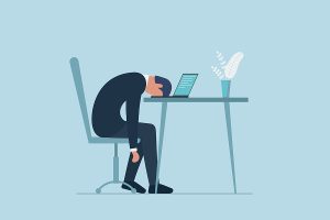 Businessman dejected at computer in office.