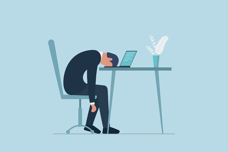 Businessman dejected at computer in office.