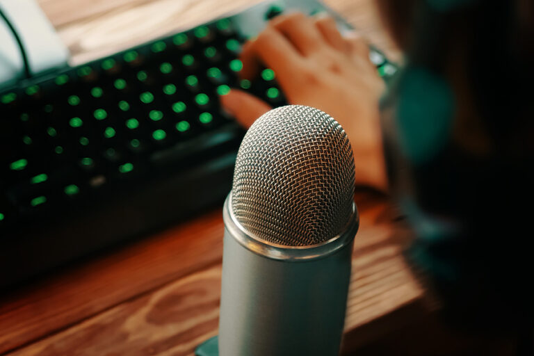 Person on computer speaking into a microphone. Online speaking, webinar, or podcast.