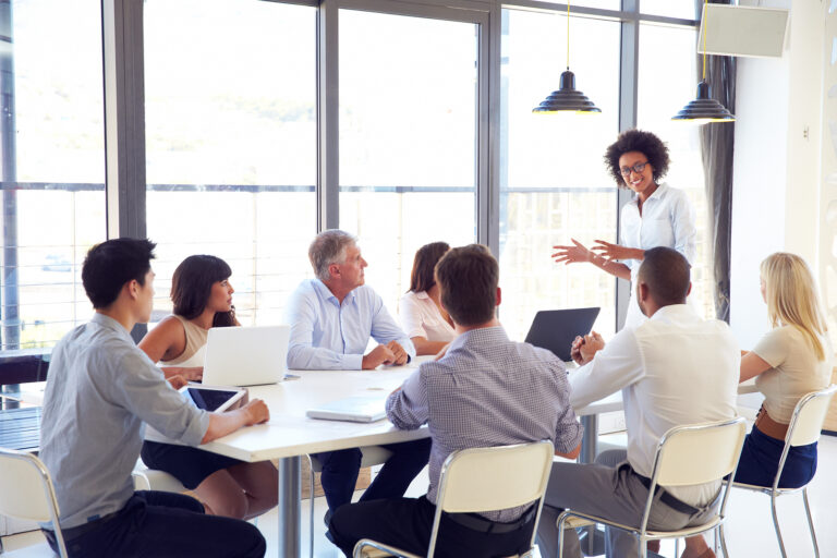 Sales and marketing teams in a meeting with a presentation.