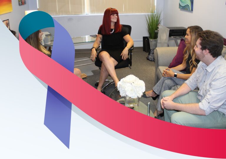 Julia Becker Collins sitting in her office with interns with Thyroid Cancer Awareness Ribbon in foreground.