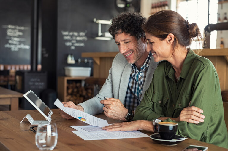 Small business partners sitting at table in coffee shop and applying researching tools to help them during the COVID-19 pandemic